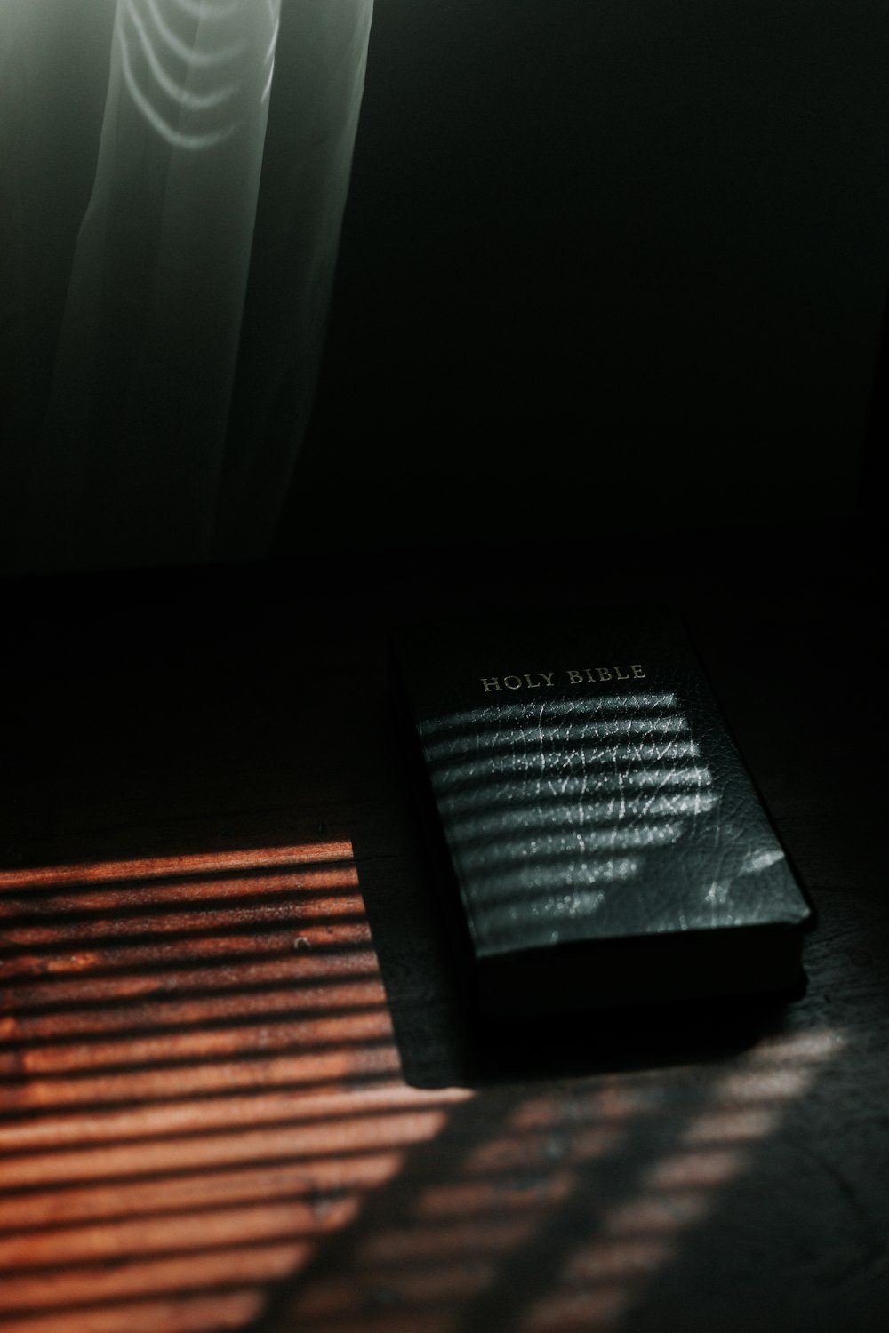 Schwarzes Buch auf braunem Holztisch