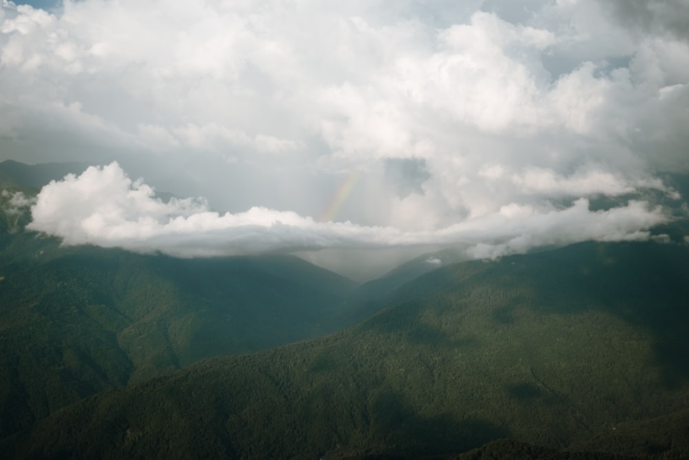 montagnes vertes sous des nuages blancs pendant la journée