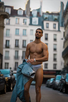Model wearing a Baviera shirt in a sunlit urban setting, showcasing relaxed yet refined style.
