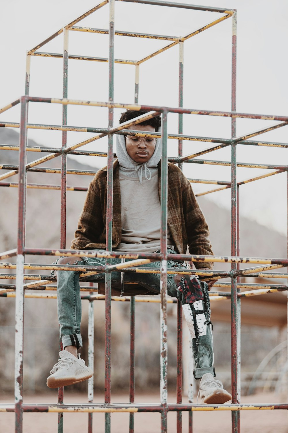 man in brown sweater and brown pants standing on metal ladder during daytime