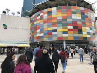 A bustling commercial building with people entering and exiting.
