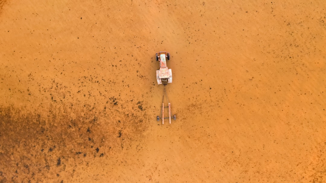 aerial view of white and gray boat on brown sand