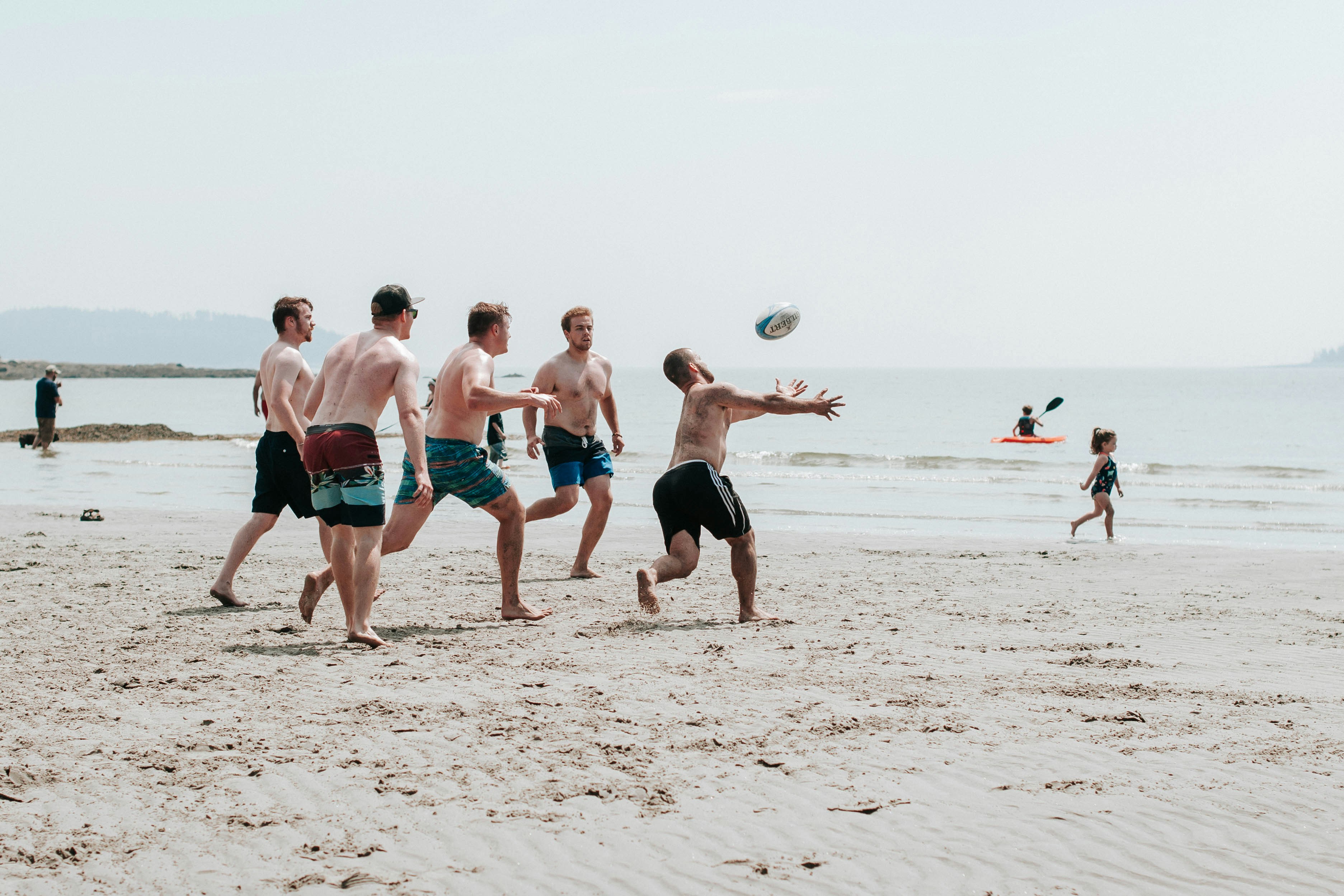 a diverse team energetically playing beach volleyball - team building beach