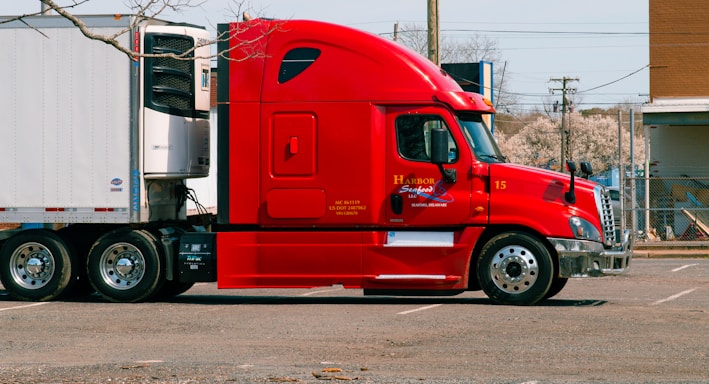 red and white truck on road during daytime