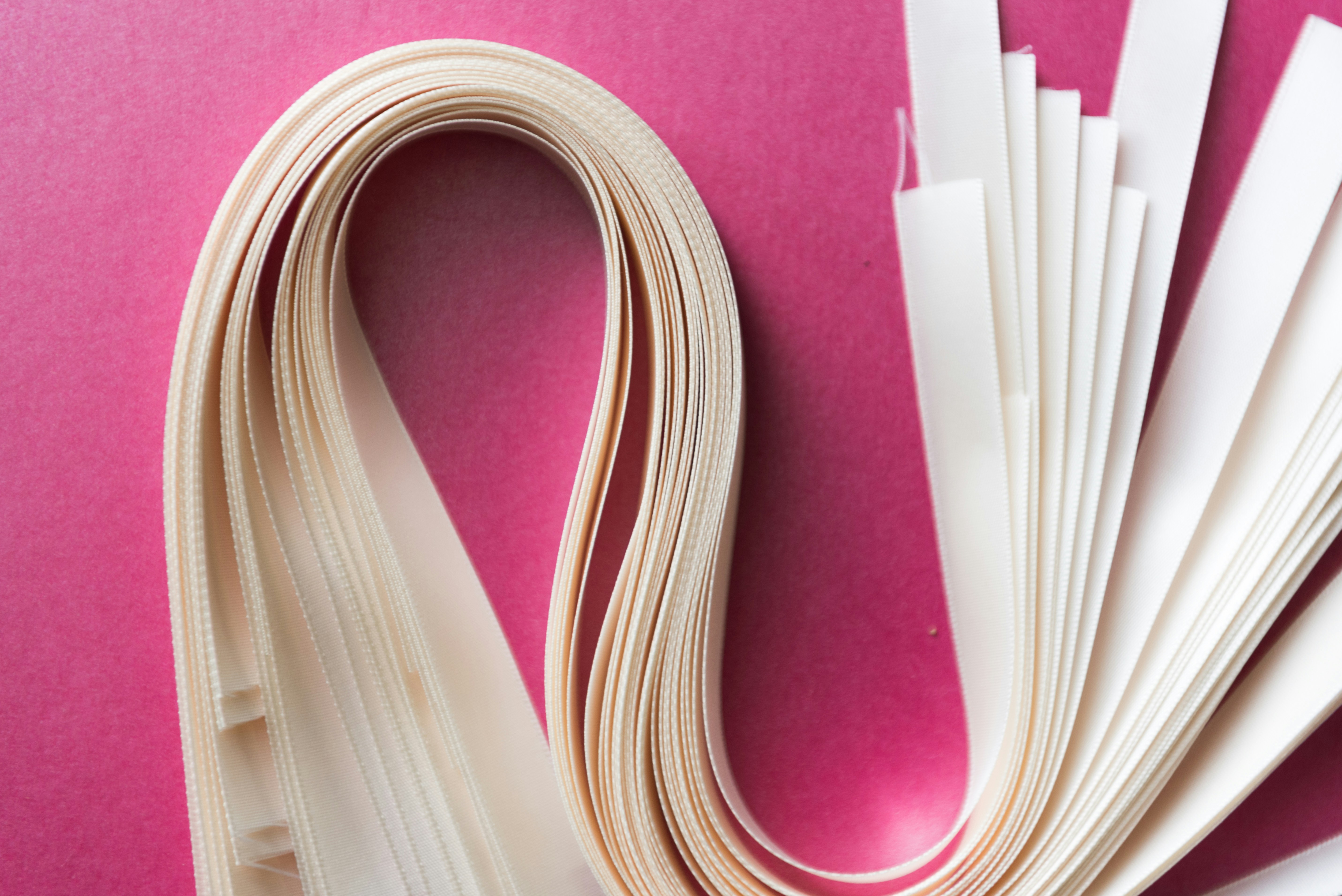 Aufgerollte weiße und violette Papierstreifen in Quilling-Technik