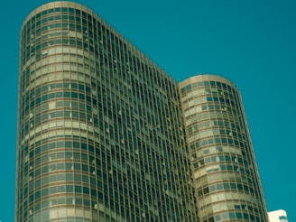 Modern office building with glass facade reflecting city skyline.