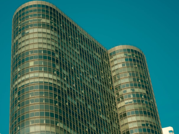 Modern office building with glass facade reflecting city skyline.