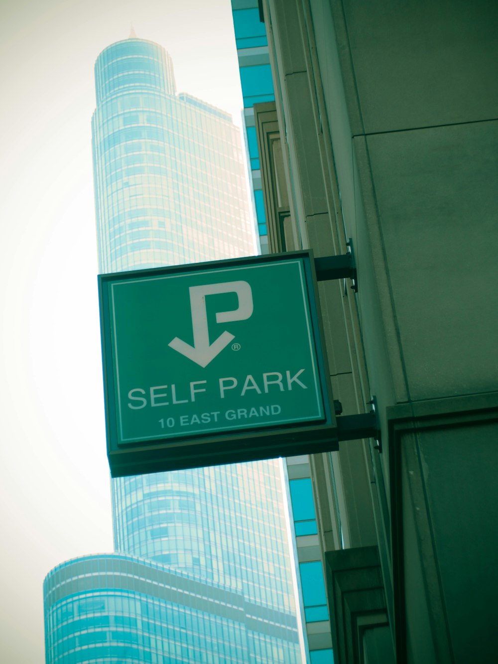 a green sign hanging from the side of a building