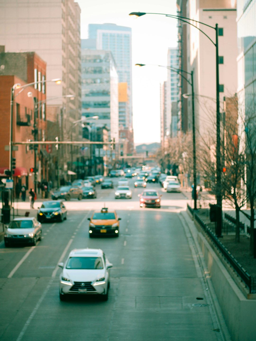 cars on road between high rise buildings during daytime