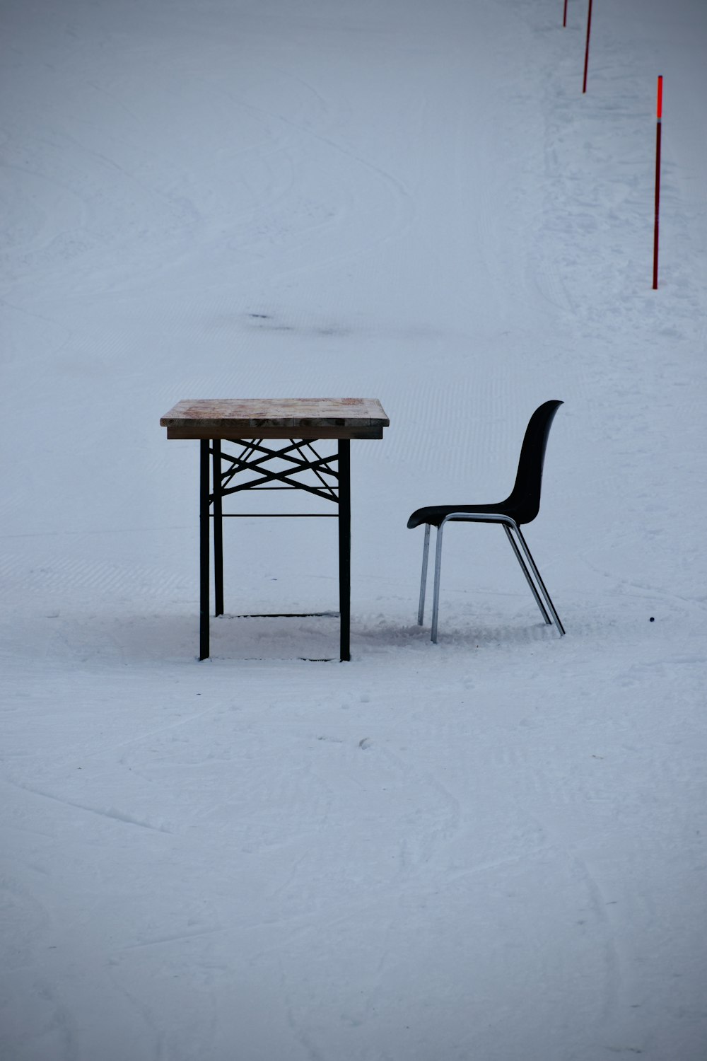 brown wooden table on snow covered ground