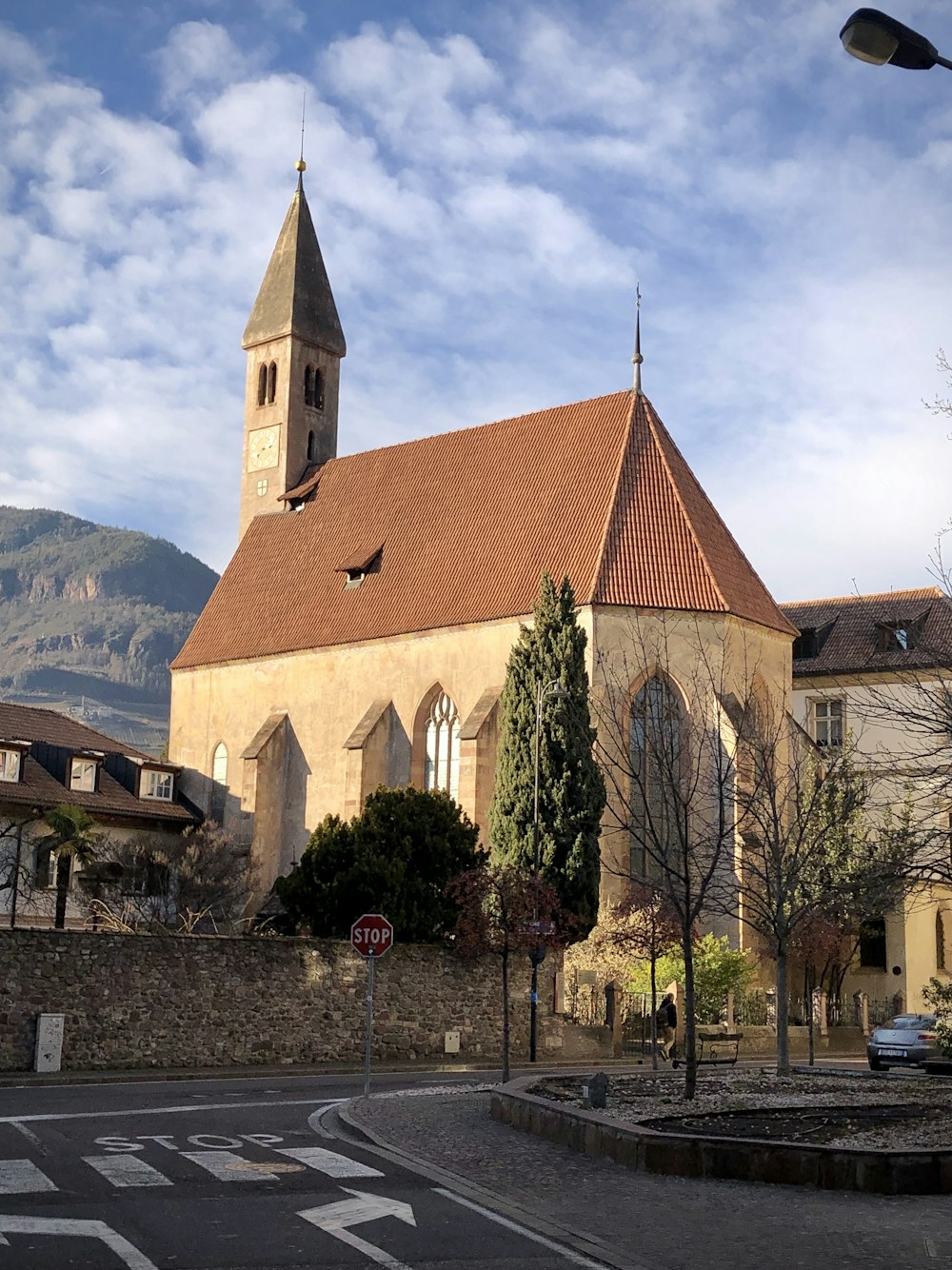 brown and white concrete church near green trees during daytime