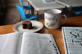 white and green ceramic mug beside white printer paper
