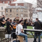 man in blue long sleeve shirt playing electric guitar