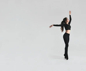 A minimalist composition showing a dancer’s silhouette against a deep black background.