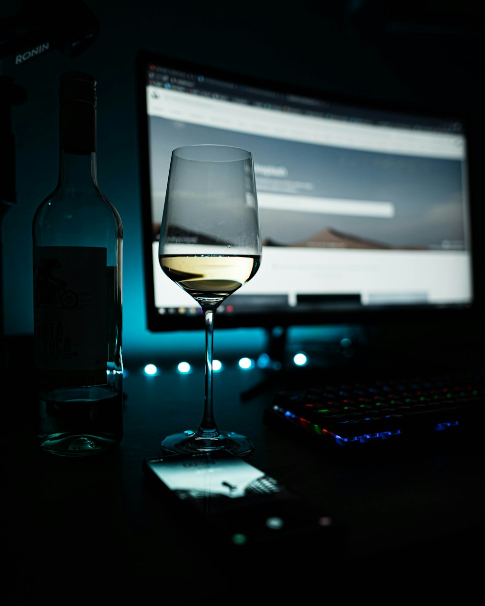 clear wine glass beside black computer keyboard