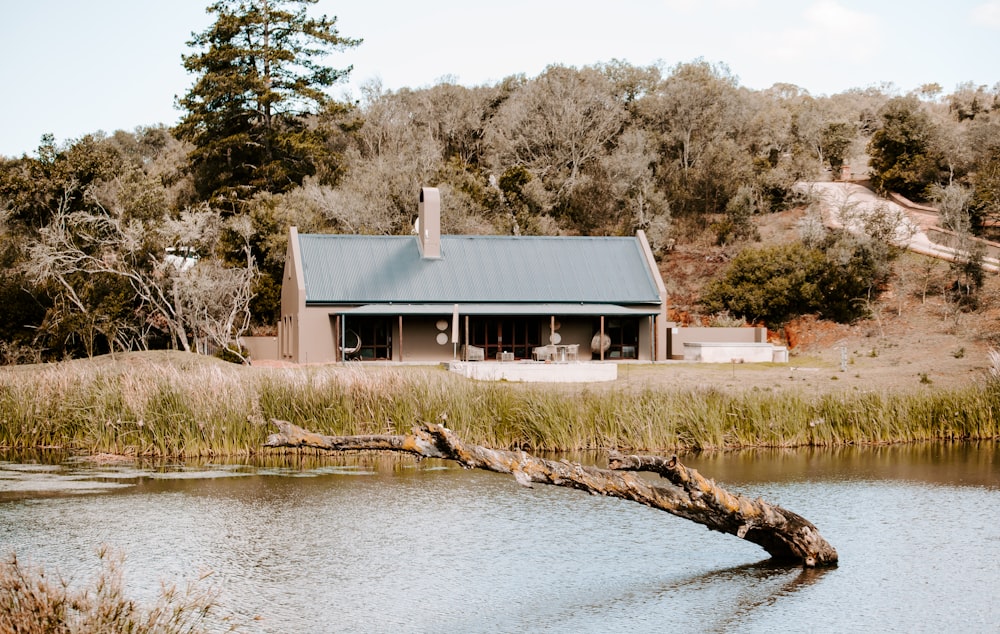 brown wooden house near body of water during daytime