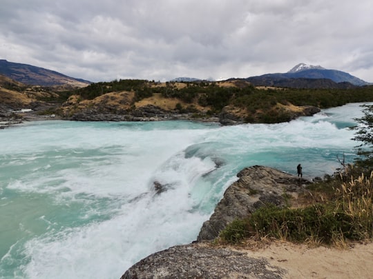 person standing on rock near body of water during daytime in Confluencia Rio Baker Chile