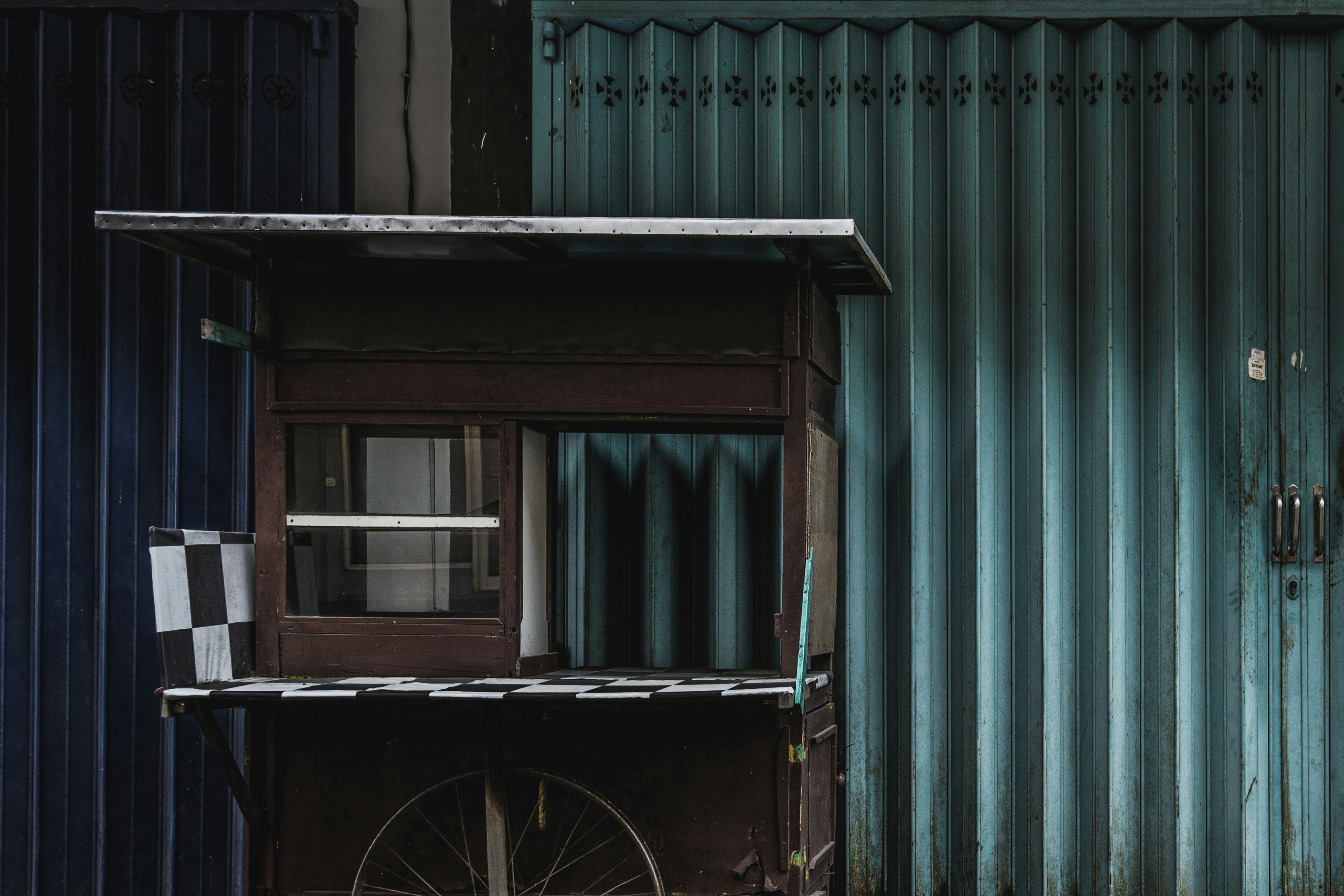 black bicycle parked beside green wooden house