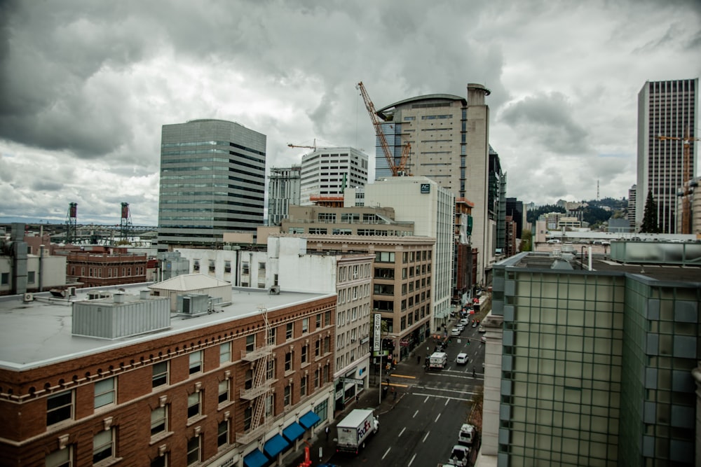 cars parked on parking lot near high rise buildings during daytime