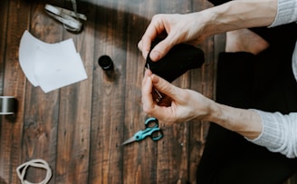 person holding blue and black scissors