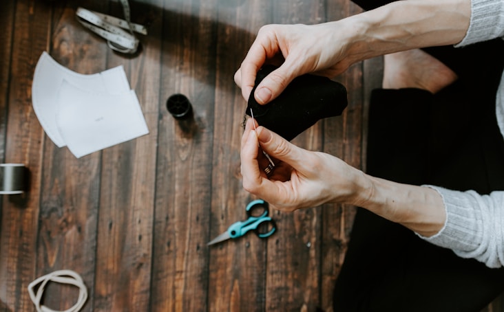 person holding blue and black scissors