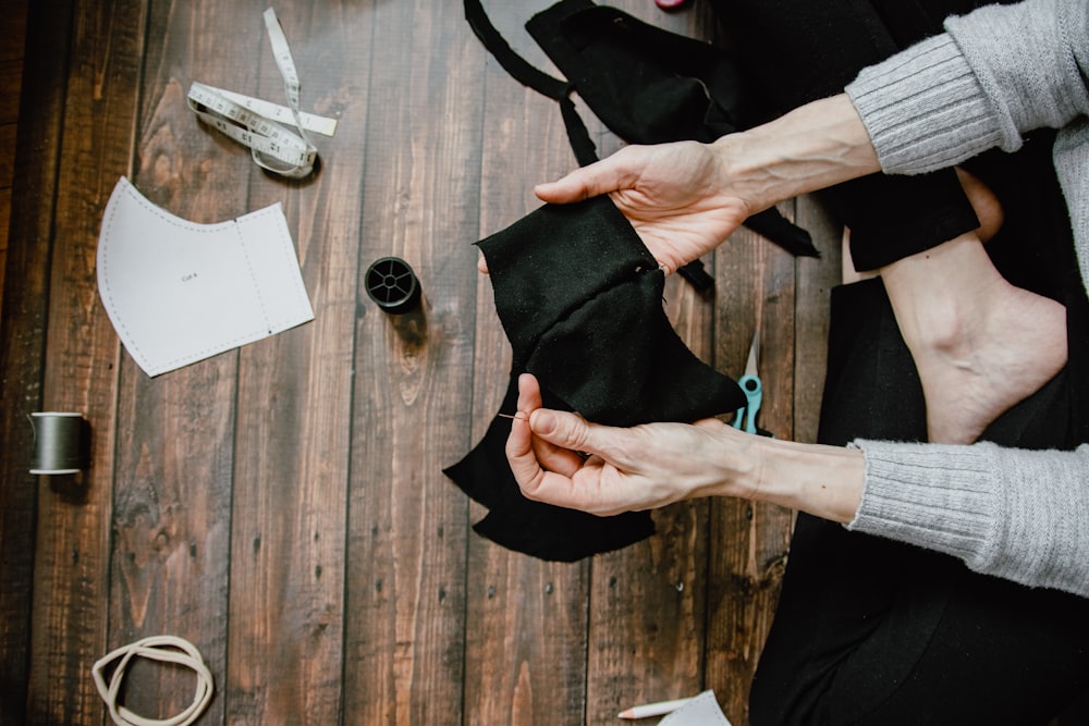 person holding black leather bag