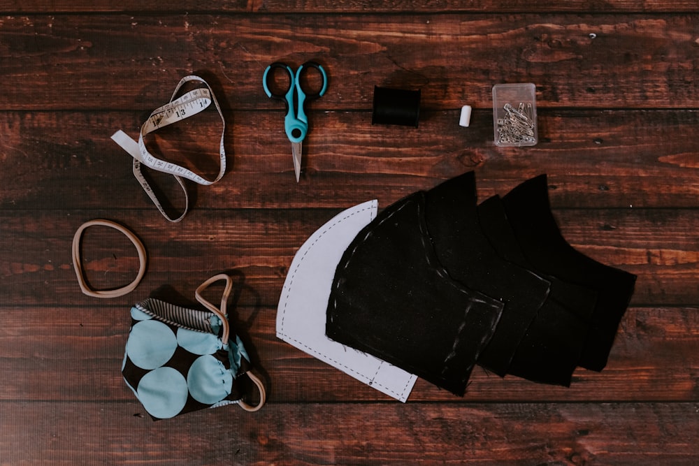 black and gray scissors beside black leather bag