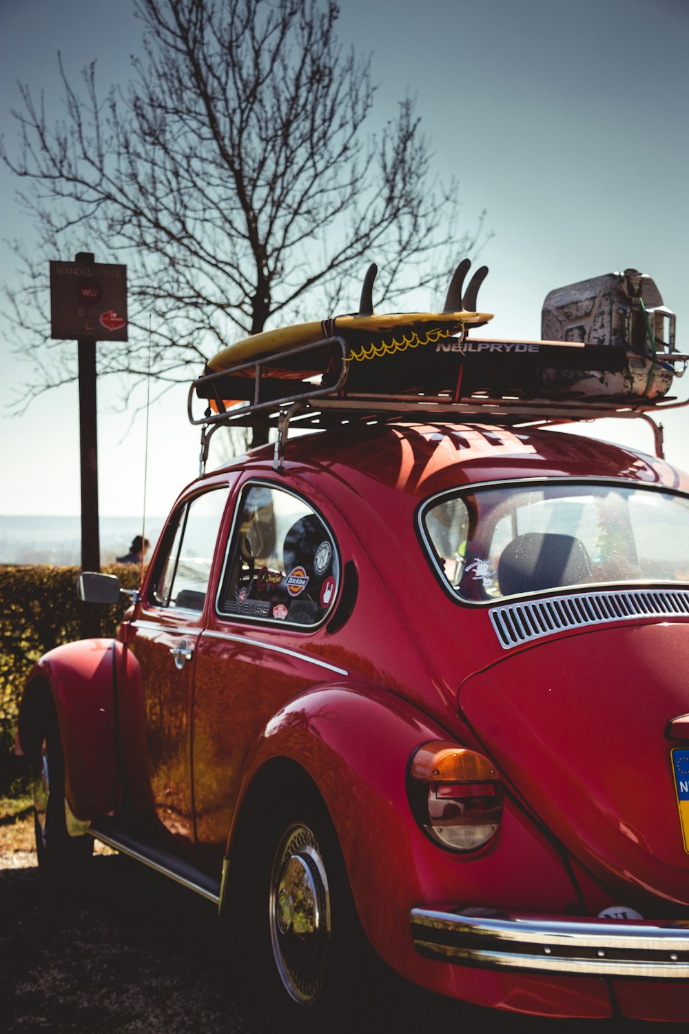 red and yellow vintage car parked on the side of the road