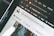 Close-up of a computer screen displaying an open web browser with multiple tabs, including a tab showing the Unsplash website. Other visible icons include web apps like Gmail, YouTube, and Maps. The search bar on the page invites users to look for free high-resolution photos.