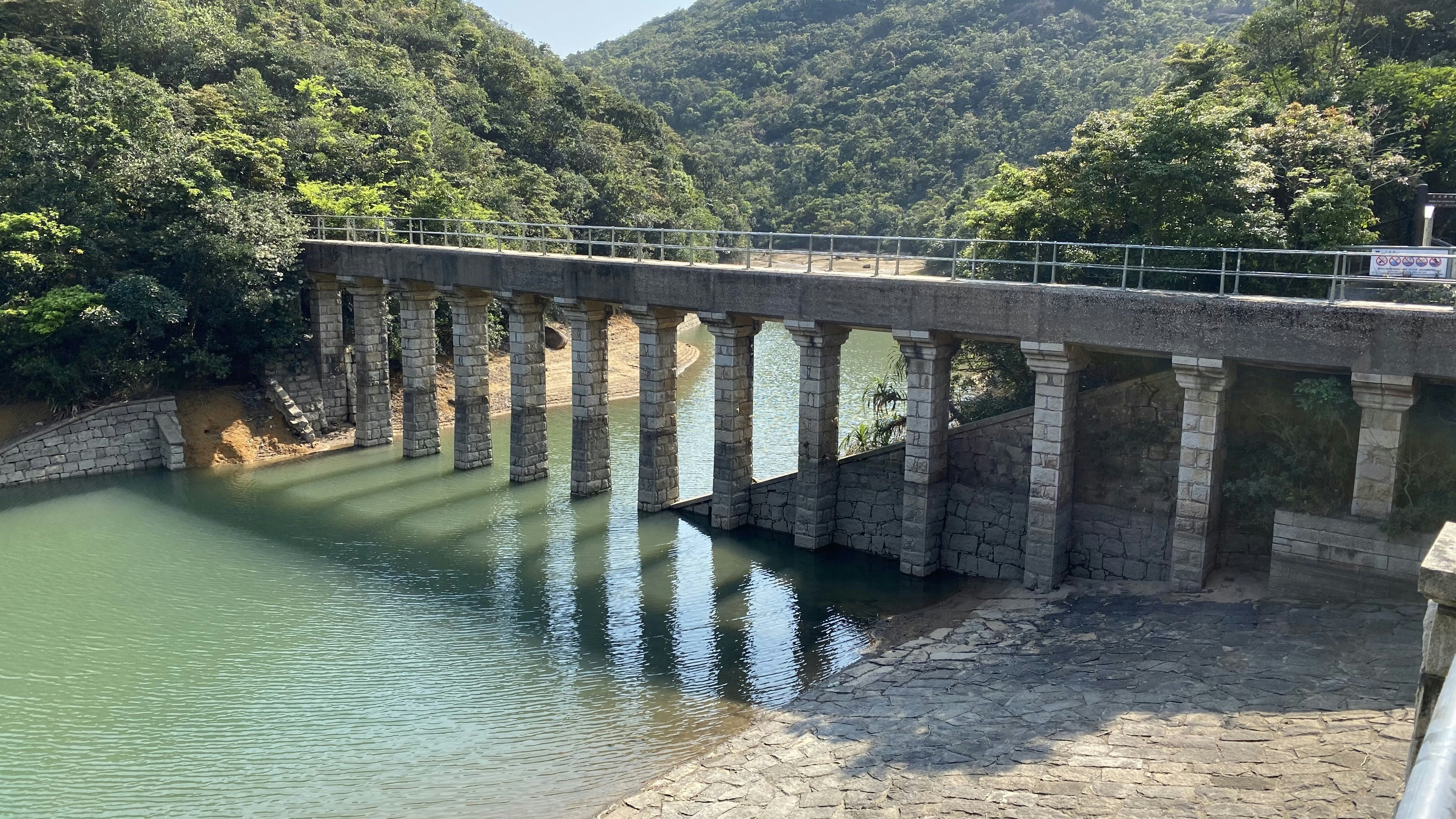 a bridge over a body of water surrounded by mountains
