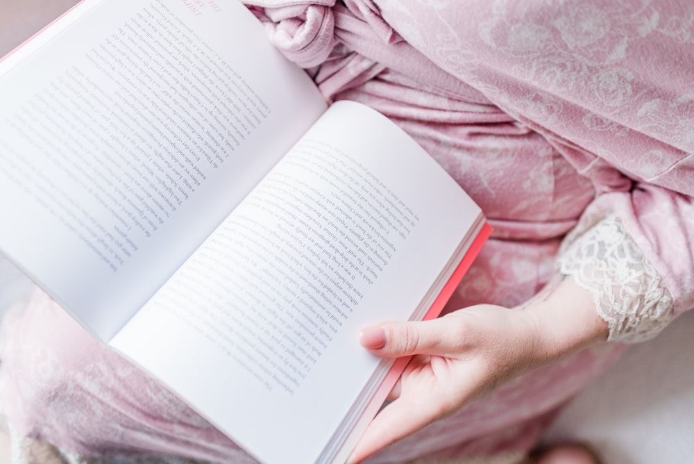 person holding white book page