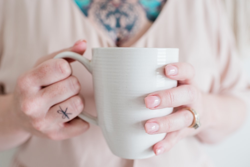 person holding white ceramic mug