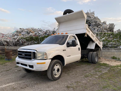 Scrap removal truck packed with metal scraps, parked at a recycling center.