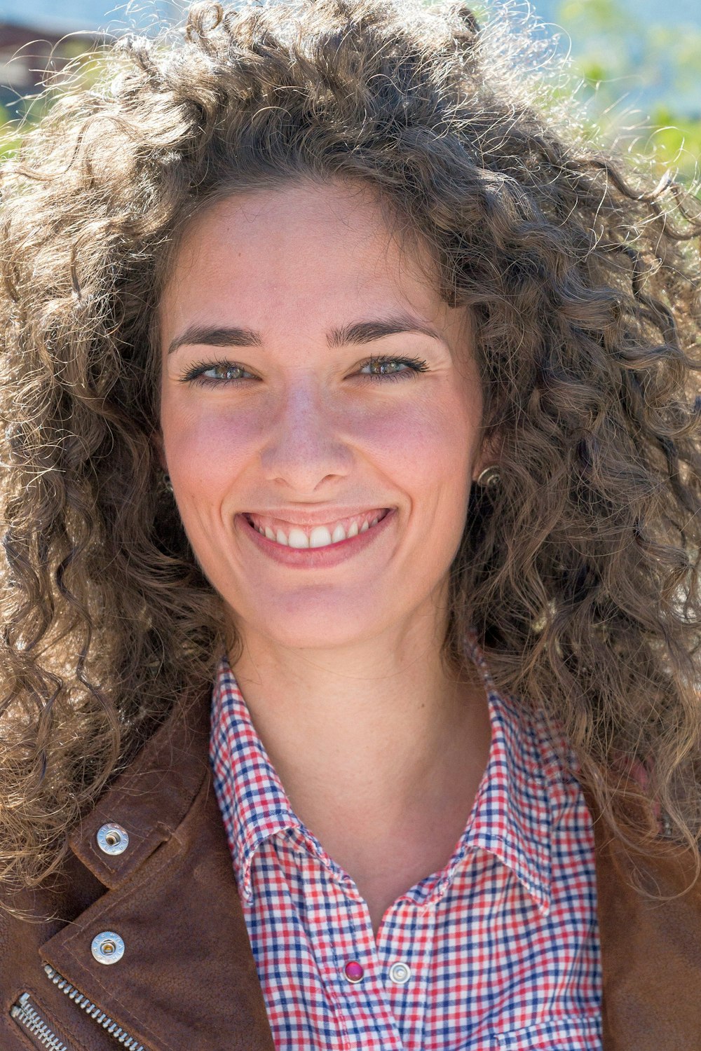 Mujer en chaqueta marrón sonriendo