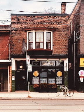 A welcoming storefront in Old City Philadelphia with a vintage sign and flower boxes.