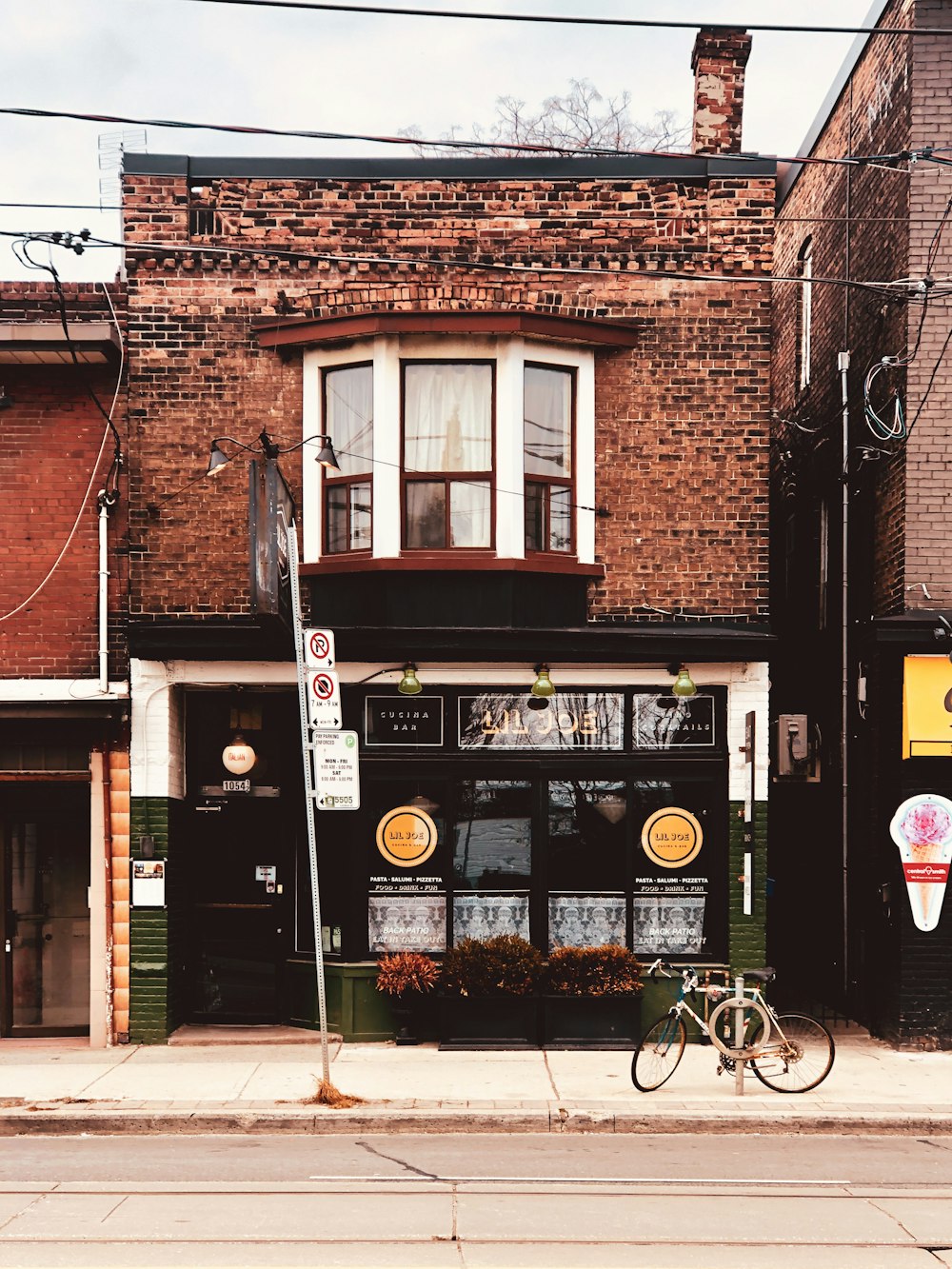 brown brick building with black metal framed glass window