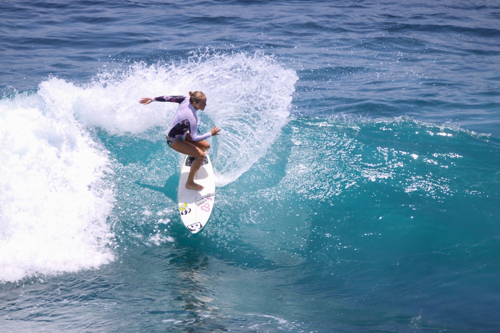 woman in black bikini surfing on sea waves during daytime