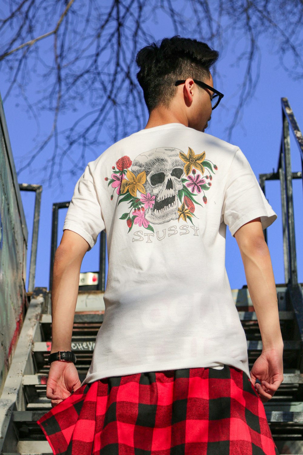 man in white crew neck t-shirt standing on bridge during daytime