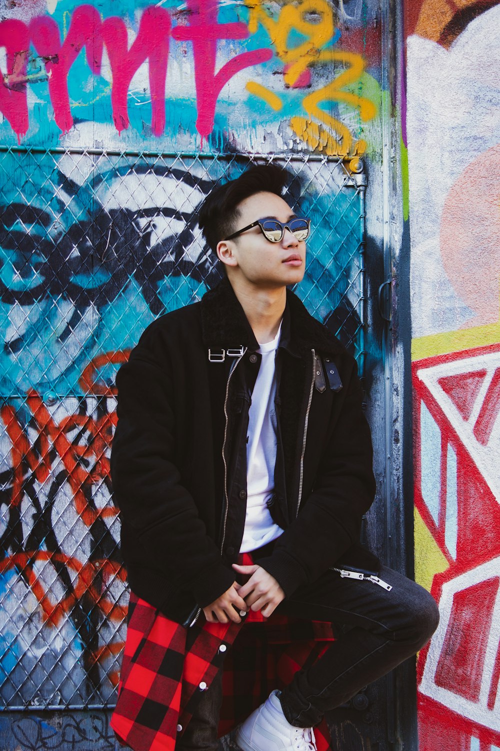 man in black zip up jacket and black pants wearing black sunglasses