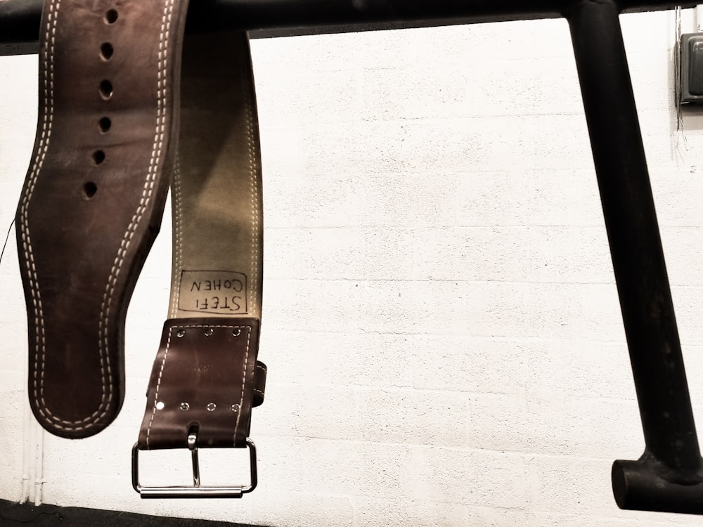 brown leather belt on white textile