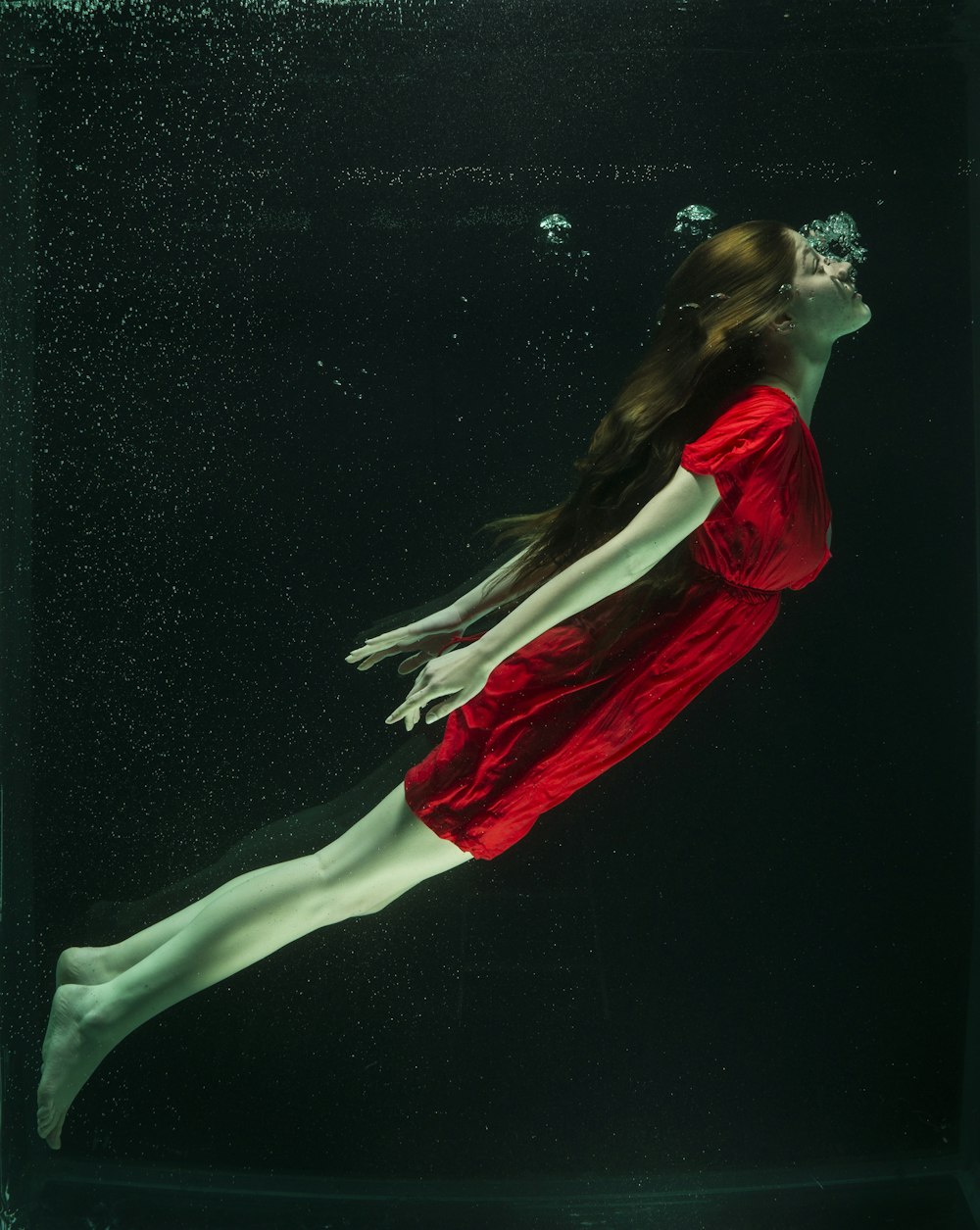 femme en robe rouge couchée sur l’eau