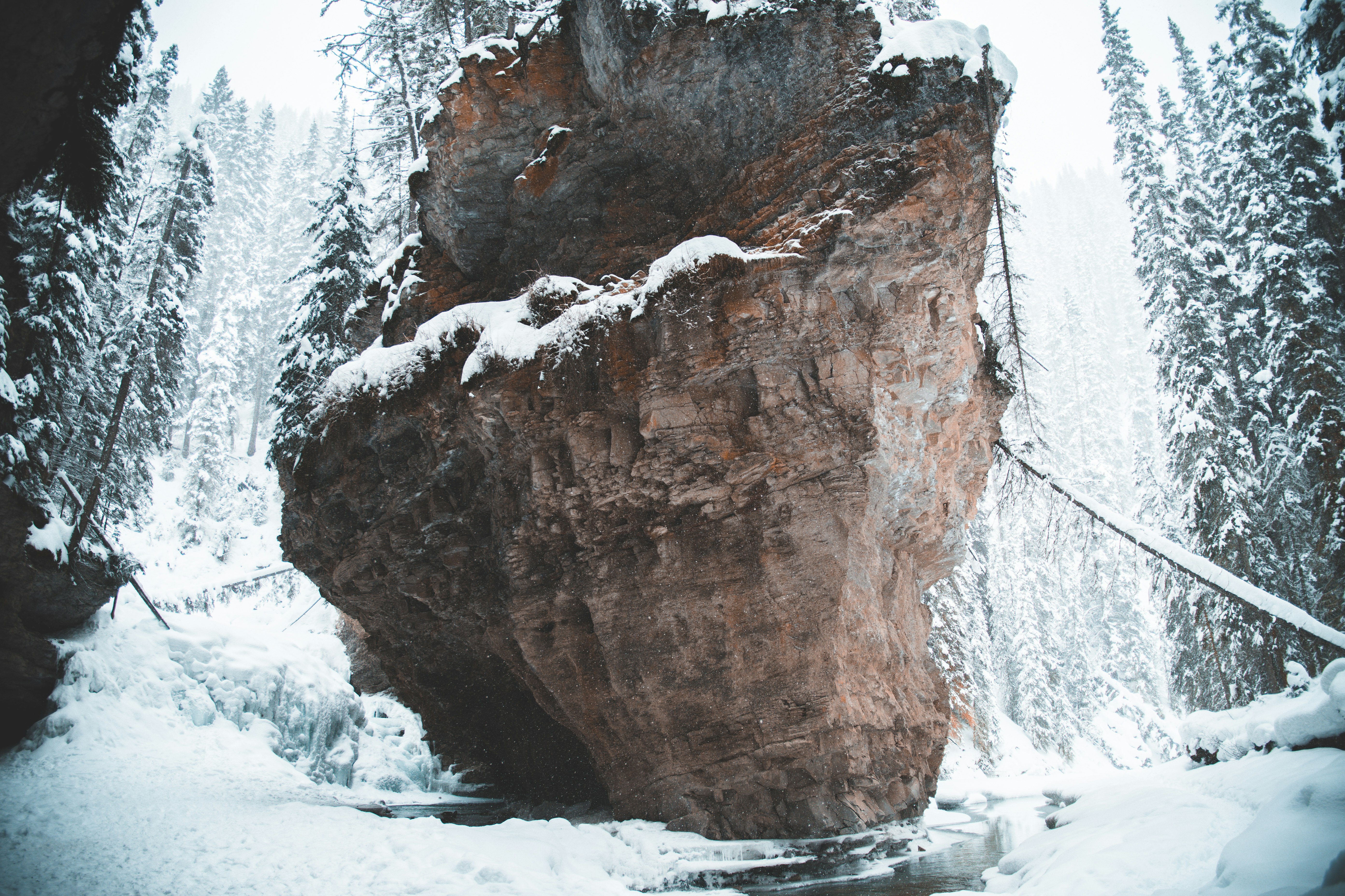 brown rock formation covered with snow during daytime