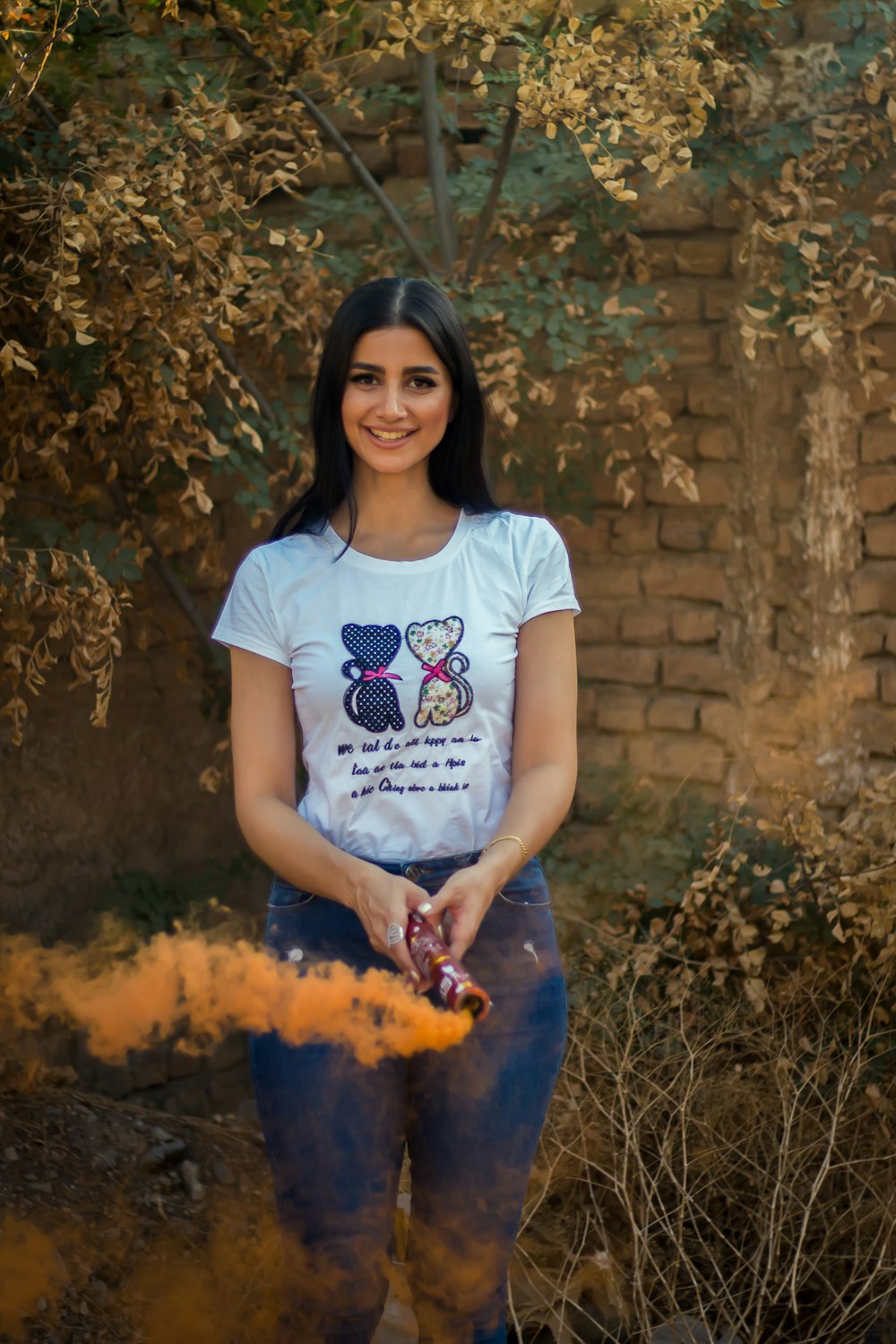 woman in white t-shirt and blue denim jeans holding fire