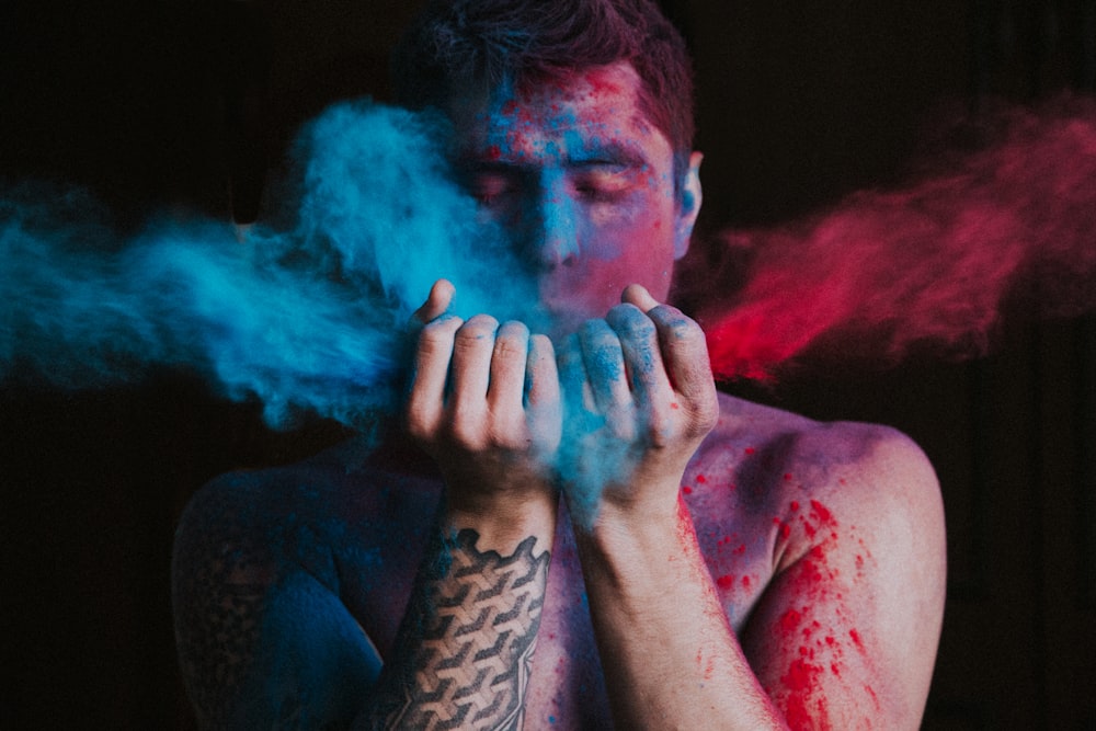 man in black shirt with blue powder on his face