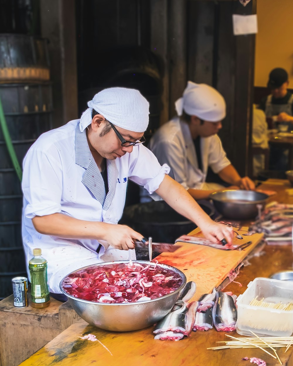 woman in white chef hat and white apron slicing red vegetable