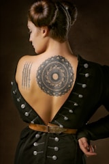 woman in black geometric tattoo on her back