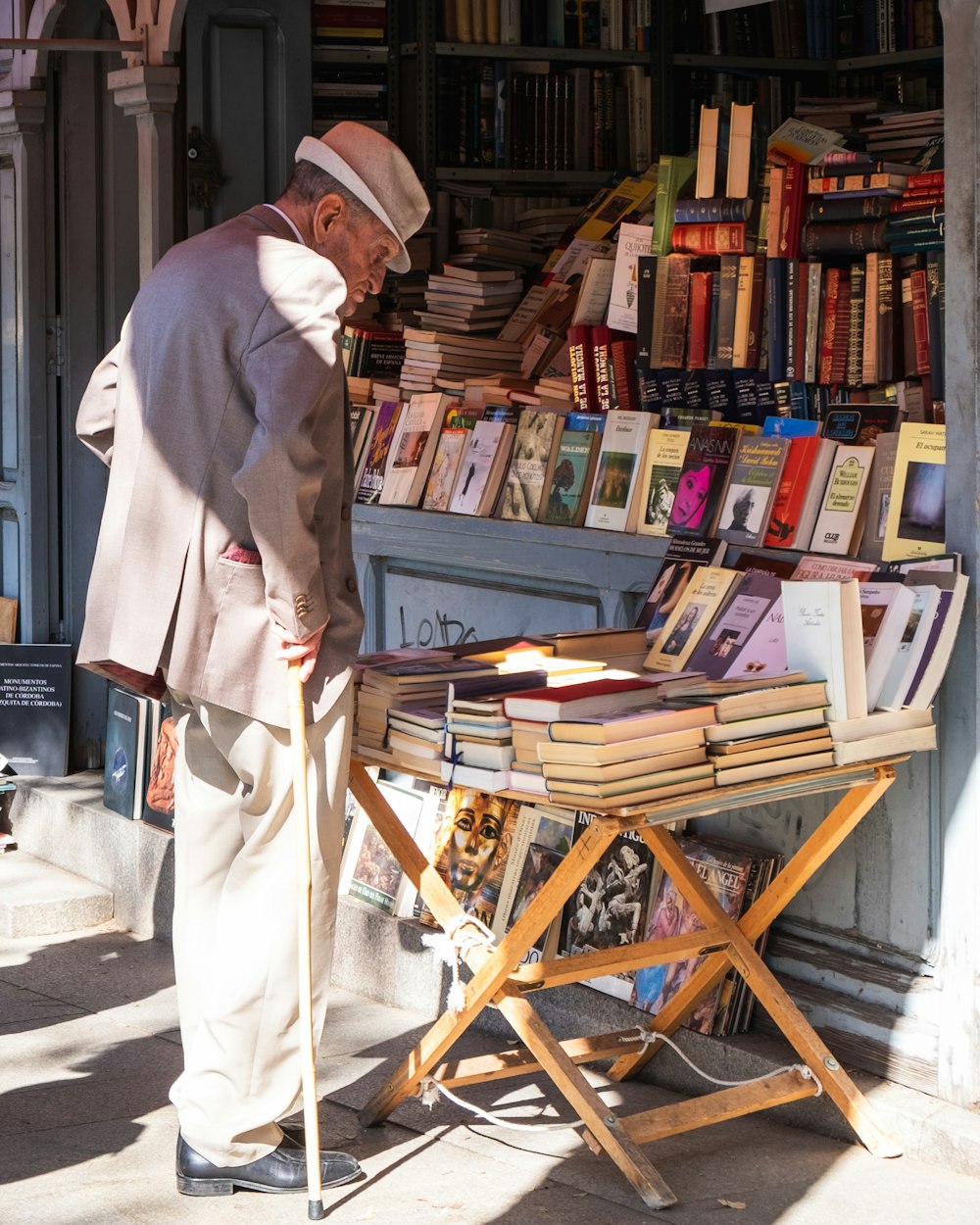 man in white thobe standing beside brown wooden chair