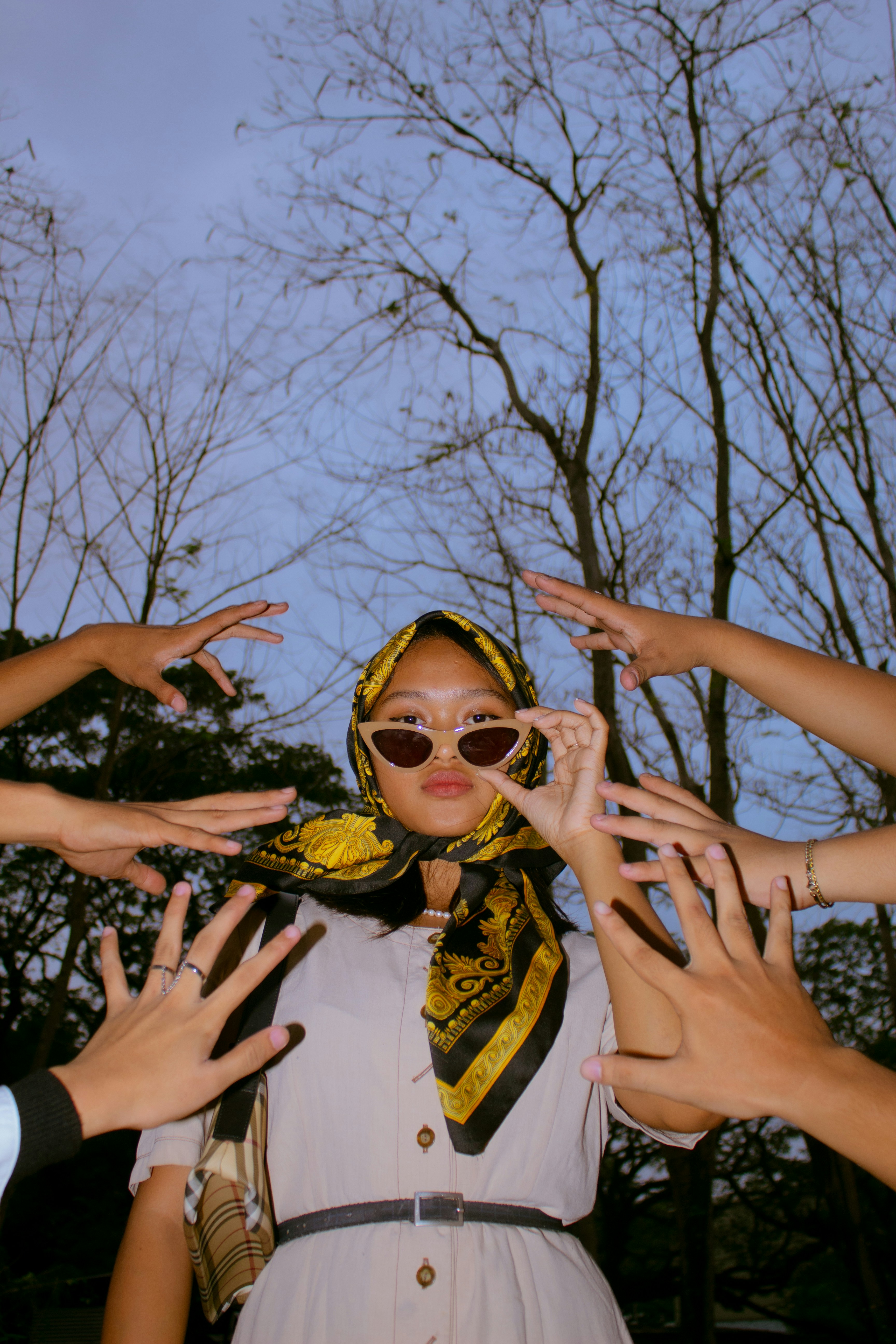 woman in yellow framed sunglasses and white and black floral dress