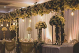 A stylish mobile bar setup at an elegant wedding reception with soft lighting and floral decorations