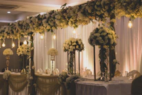 Elegant wedding setup featuring deep navy blue and gold decorations under soft lighting.